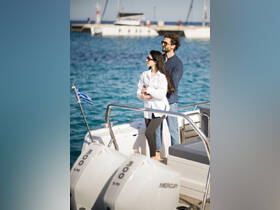A couple enjoys a romantic moment on a boat, surrounded by sparkling ocean waters — perfect for a sunny day out at sea.