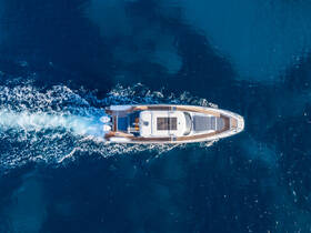 A stunning aerial view of a sleek yacht cruising through deep blue waters, showcasing its elegant design and smooth movement.