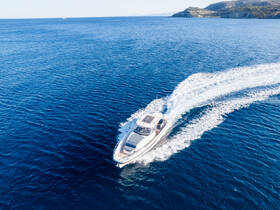 A stunning aerial view of a sleek speedboat cruising through deep blue waters, showcasing the vessel's design and performance.