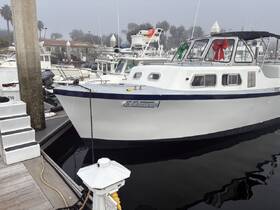 A classic boat named 'Acapitana' docked in a marina, adorned with festive bows, surrounded by other vessels in a foggy setting.