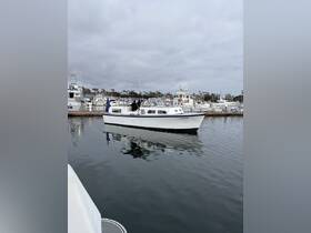 A white boat named 'La Capitana' docked in a marina, surrounded by other vessels under a cloudy sky — perfect for exploring coastal waters.