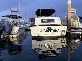 The stern view of 'La Capitana' docked in a marina, showcasing its sleek design and reflective waters — a perfect spot for boating enthusiasts in San Diego.