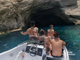 A group of friends enjoys a scenic boat ride near a cave, capturing the essence of adventure and exploration on the water.