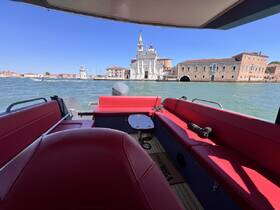 Interior view of a stylish boat cabin featuring red seating, perfect for relaxing while cruising through scenic waterways.