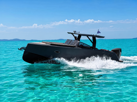 A sleek speedboat glides through crystal-clear turquoise waters, showcasing an exhilarating day on the water.