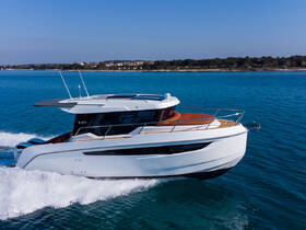 A sleek yacht named 'KAVI' cruising through clear blue waters, showcasing its elegant design and powerful performance.