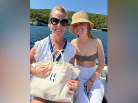 A joyful moment captured on a boat, featuring two women enjoying a sunny day on the water — perfect for summer adventures and memorable outings.