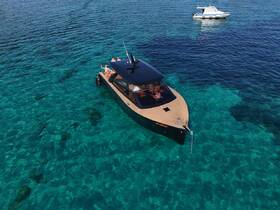 Aerial view of a stylish boat with guests enjoying the clear turquoise waters, showcasing the perfect setting for a day of relaxation and adventure on the water.