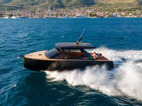 A sleek speedboat cuts through the waves, showcasing its modern design and luxurious features while underway in beautiful waters.