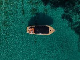 Aerial view of a group enjoying their time on a boat in crystal-clear waters, perfect for summer adventures and relaxation.