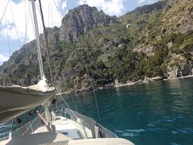 A stunning view from the deck of a sailboat, showcasing the majestic cliffs and clear waters, perfect for exploring coastal landscapes.