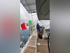 A sailor navigates from the helm of a sleek sailboat, showcasing the interior design and functionality of the cabin while under sail.