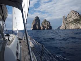 A stunning view of rocky islands as seen from a sailing yacht, showcasing the beautiful coastline and inviting waters — perfect for adventure seekers and nature lovers.