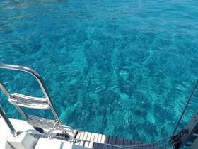 An unclear view of the water from a boat, showcasing the vibrant turquoise color but lacking identifiable features or subjects.