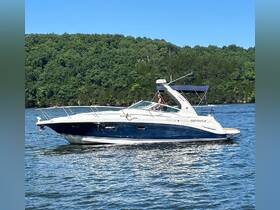 A Four Winns boat glides through serene waters, showcasing a beautiful day on the lake with a guest at the helm.