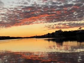 A stunning sunset casts vibrant colors across the water, creating a picturesque reflection — a perfect backdrop for evening boat trips or relaxing moments by the shore.