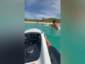A thrilling moment captured on a jet ski, showcasing the excitement of water sports against a beautiful beach backdrop.