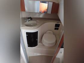 Interior view of a boat bathroom featuring a sink and toilet, showcasing the compact and functional design typical of marine facilities.