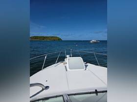 A stunning view from the front of a yacht cruising through clear waters, with a lush island in the background — perfect for exploring beautiful destinations.