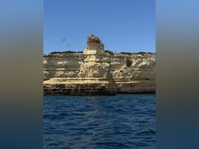 A stunning view of a unique rock formation along the coastline, showcasing the natural beauty of the area — perfect for sightseeing and exploration during boat trips.