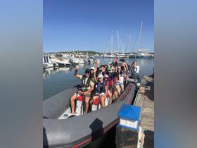 A lively group waves from a boat at the marina, ready for an exciting day on the water — perfect for group adventures and celebrations.