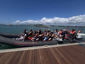 A lively group prepares for an adventure on the 'Ocean Whisper' boat, showcasing the excitement of a day on the water with friends and family.