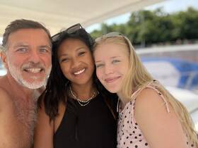 A joyful group poses for a selfie on a boat, capturing a memorable moment of fun and friendship on the water.