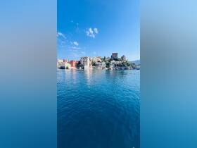A picturesque view of a colorful coastal town reflecting on calm waters, perfect for showcasing beautiful destinations during boat trips.