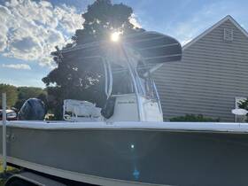 A sleek view of a center console boat, showcasing its design and structure under a bright sky, perfect for fishing or leisure outings.