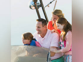 A joyful family enjoys a fun moment on a boat, with children actively engaged and smiling, capturing the essence of memorable boating experiences.
