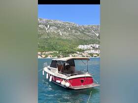 A picturesque view of a boat docked in clear waters, surrounded by scenic hills and coastal homes, perfect for exploring the beautiful landscape.