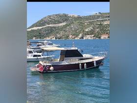 A beautiful view of the Antares boat docked in clear waters, surrounded by scenic hills and coastal architecture, perfect for exploring the coastline.