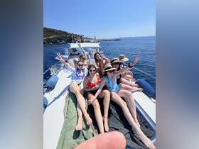 A lively group of friends enjoys a sunny day on a boat, celebrating and having fun on the water — perfect for summer outings and memorable adventures.