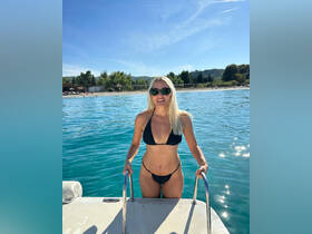 A woman enjoys a sunny day by the water, showcasing the perfect beach vibe — ideal for summer adventures and relaxation.