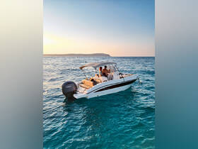 A couple enjoys drinks on a boat during a stunning sunset, creating a perfect romantic atmosphere on the water.