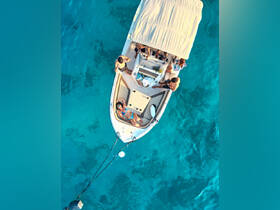 A group enjoys a sunny day on a boat, with one person relaxing on the deck while others engage in fun activities — perfect for summer outings and water adventures.
