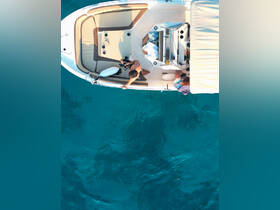 An aerial view of guests enjoying their time on a boat, showcasing the vibrant turquoise waters below — perfect for summer adventures and water activities.
