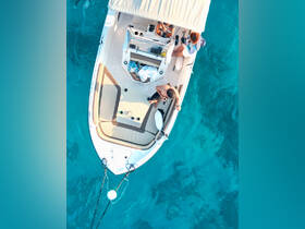 Aerial view of a group enjoying their time on a boat, capturing memories against the stunning backdrop of clear turquoise waters.