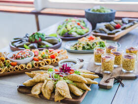 A beautifully arranged spread of gourmet dishes and drinks on a boat, perfect for catering services during your maritime adventures.