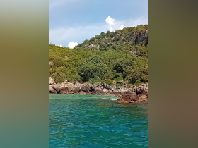 A stunning view of a lush coastline with rocky formations and clear turquoise waters, perfect for exploring hidden beaches and enjoying nature's beauty.