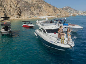 A lively group of friends celebrates on the deck of a yacht, enjoying the beautiful coastal scenery — perfect for memorable boating adventures.
