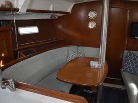 A cozy interior view of a boat's cabin featuring comfortable seating and a dining area, perfect for relaxing during a sailing trip.