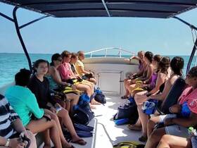 A lively group of young adventurers prepares for a snorkeling trip aboard a boat, showcasing the excitement of exploring underwater wonders.