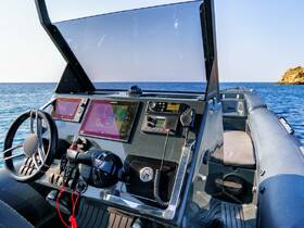 A detailed view of the helm and console of a modern boat, showcasing advanced navigation equipment and controls, perfect for boating enthusiasts.