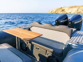 Interior view of a boat's seating area featuring a wooden table and sleek design, perfect for relaxing on the water.