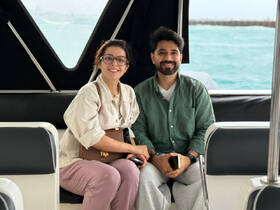 A couple enjoys a cozy moment inside a boat cabin, showcasing the comfortable seating and inviting atmosphere perfect for a relaxing day on the water.