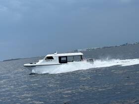 The Jupiter 11 speedboat glides through the water, showcasing its sleek design and performance on a cloudy day.