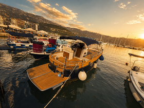 A beautiful sunset view of a yacht docked in a marina, showcasing its elegant design and tranquil surroundings.
