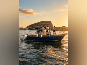 A lively group enjoys a sunset cruise on a boat, creating memorable moments against a stunning backdrop of golden skies and shimmering waters.