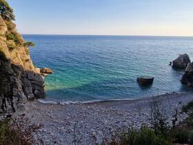 A stunning view of a secluded beach with rocky cliffs and clear turquoise waters, perfect for exploring coastal destinations and enjoying nature's beauty.